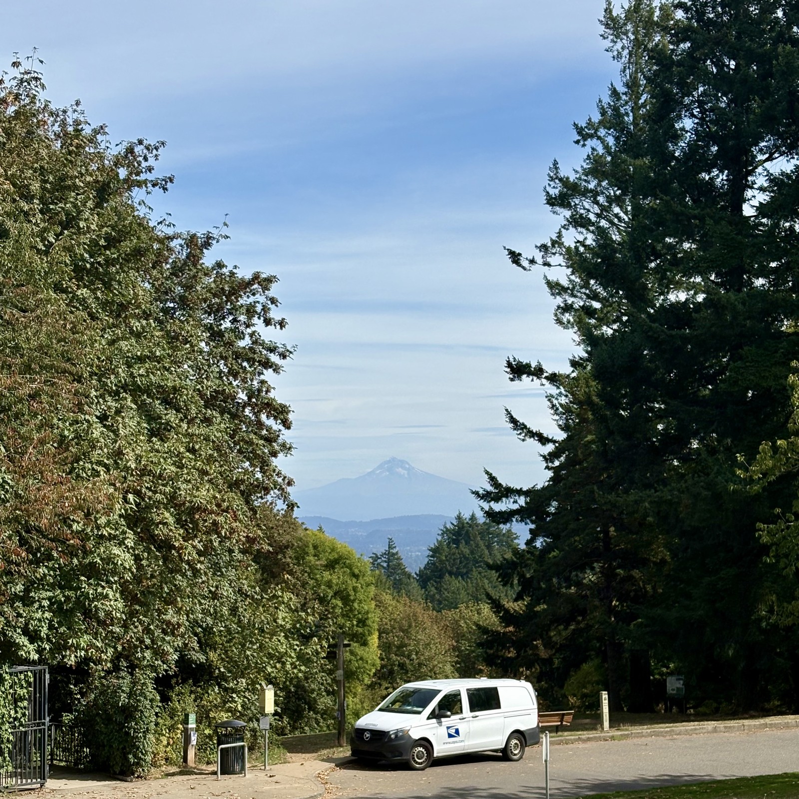 USPS parked van in the foreground; Moutnain is dim on the horizon under a sky with high cirrus clouds