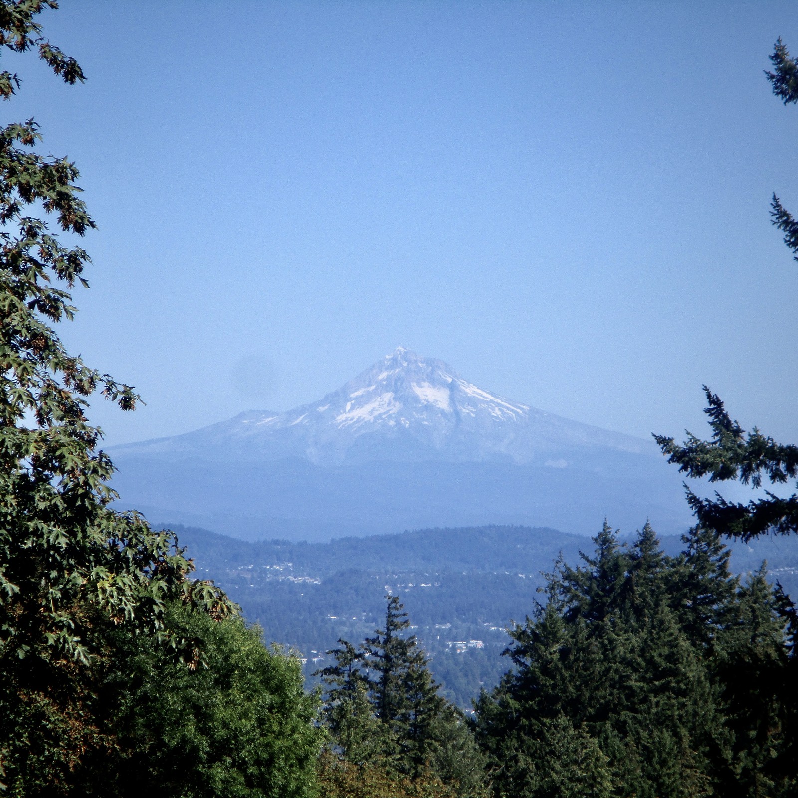 A lone volcanic peak on a very clear day, its snowfields almost completely melted, under a clear late summer sky