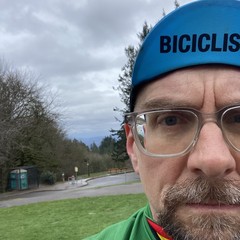 Selfie of a bearded white man with glasses and a “Biciclista” bike cap half-blocking the view toward the east, where Mt. Hood would be if it weren't gray and rainy