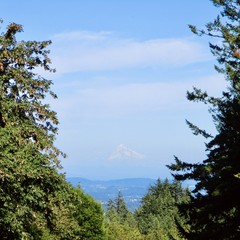 Conical volcanic peak obscured slightly by wildfire haze, on an otherwise sunny summer late afternoon