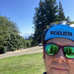 Selfie of a middle aged guy in colorful sunglasses with a Biciclista cycling cap, with mt hood in the distance, on a very clear late summer afternoon