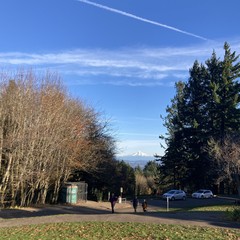 Mt. Hood under a deep blue sky with contrails, late afternoon, on an exceptionally clear cold fall afternoon. 3 people in puffy jackets are walking up the short hill from the parking lot toward the camera